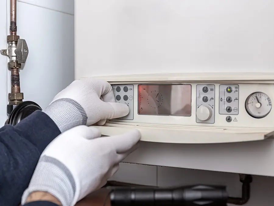 Tecnico che regola il pannello di un generatore di calore